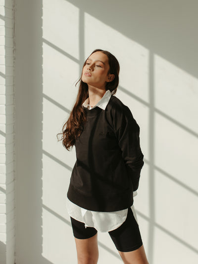 black monochrome crewneck sweatshirt with white button-down and biker shorts