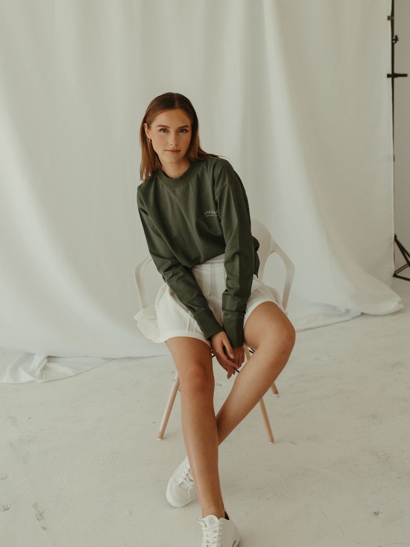 sage green crewneck sweatshirt with pleated tennis skirt