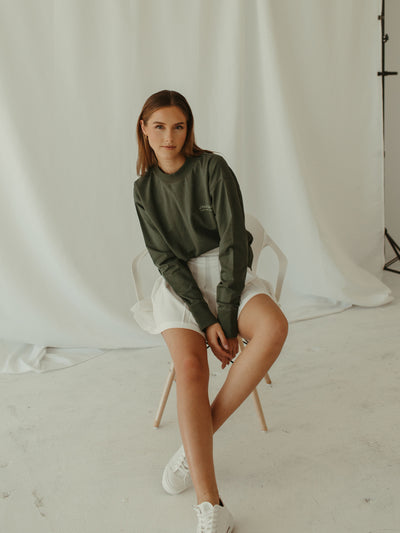 sage green crewneck sweatshirt with pleated tennis skirt