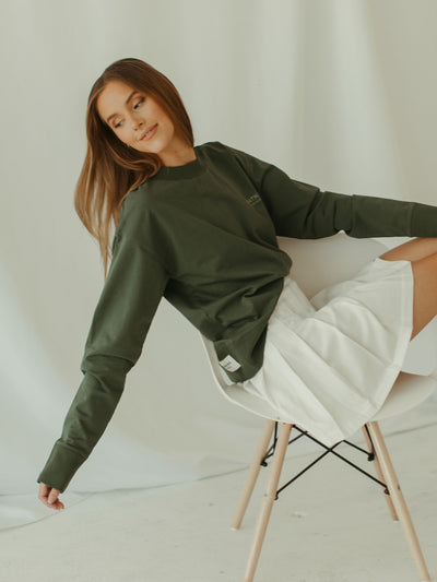 sage green crewneck sweatshirt with pleated tennis skirt