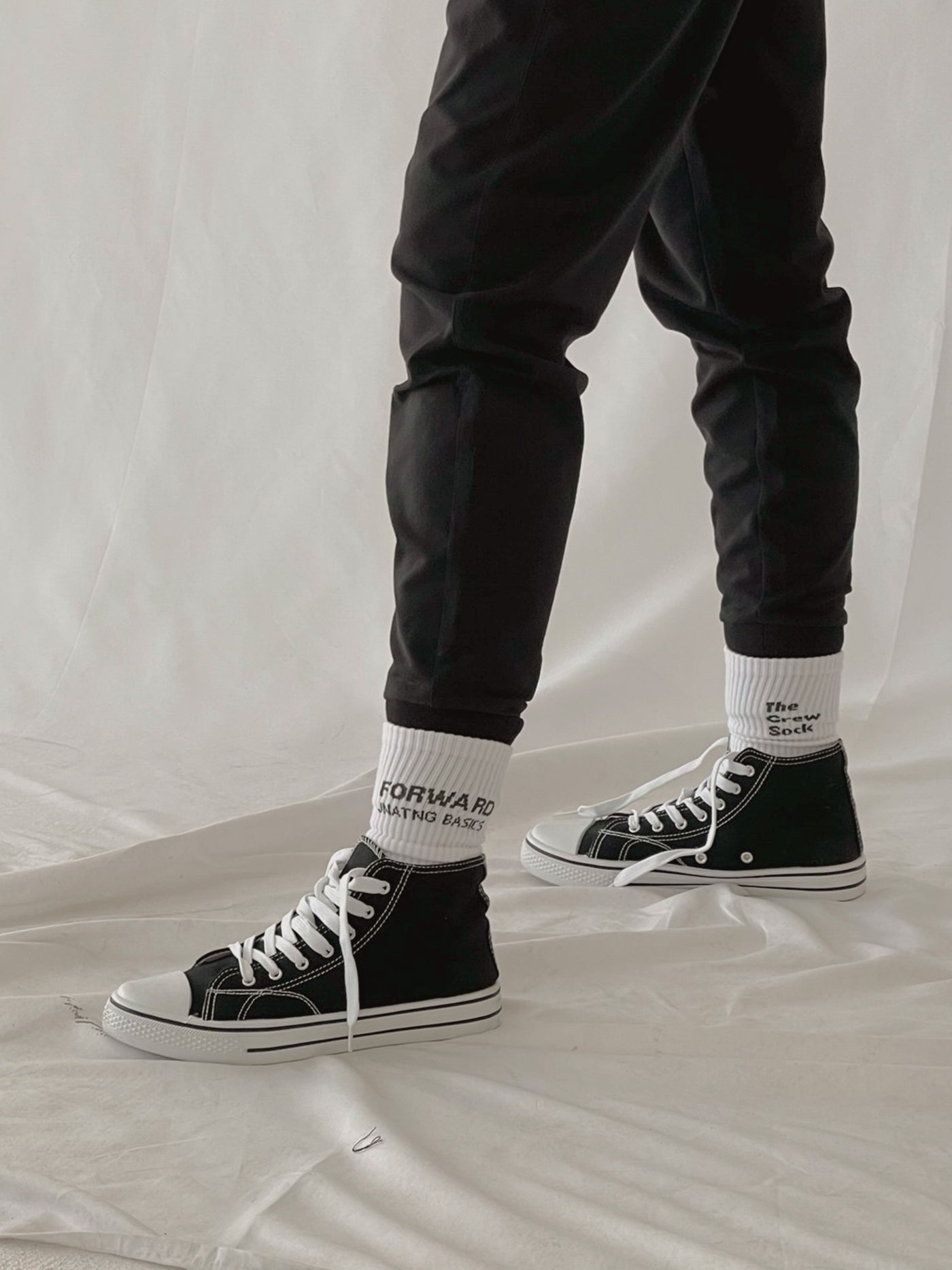 white crew socks with woven logo and black jogger